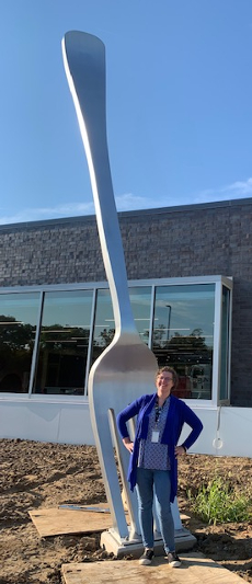 The author standing outside a building in front of a 20 foot fork.